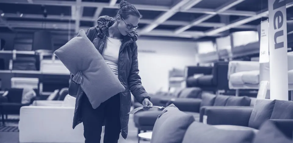 Un client choisit un coussin dans un magasin d’ameublement